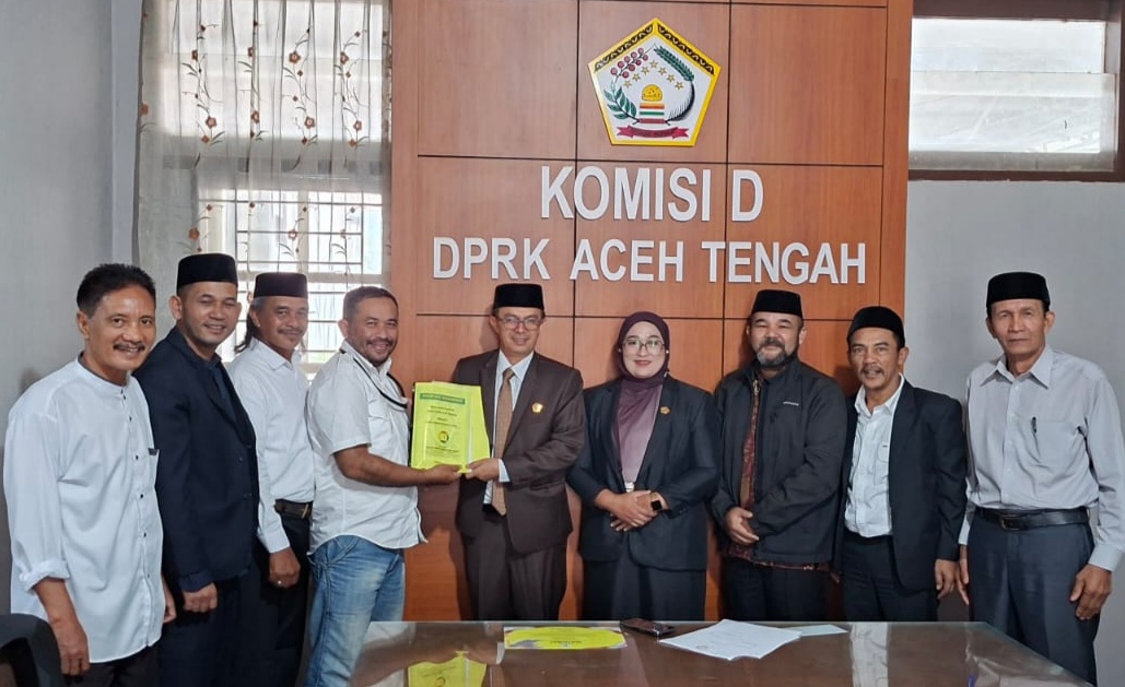 Ketua Umum Pasak Opat Nenggeri Linge, Zam Zam Mubarak, menyerahkan Naskah Akademik dan Draf Rancangan Qanun Adat Gayo kepada Ketua Badan Legislasi DPRK Aceh Tengah, Mukhlis, S.Pd., disaksikan Wakil Ketua II DPRK Aceh Tengah, Susilawati, Jumat (19/6/2026).